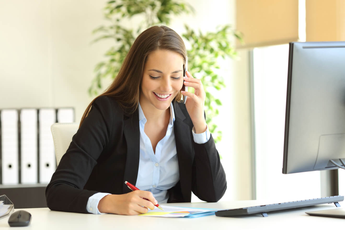 A professional listening to a voice message and taking notes