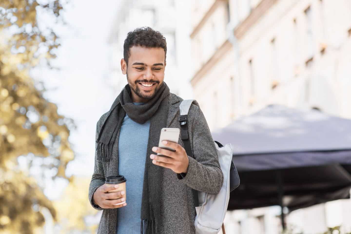 A man smiling as he reads an SMS notification