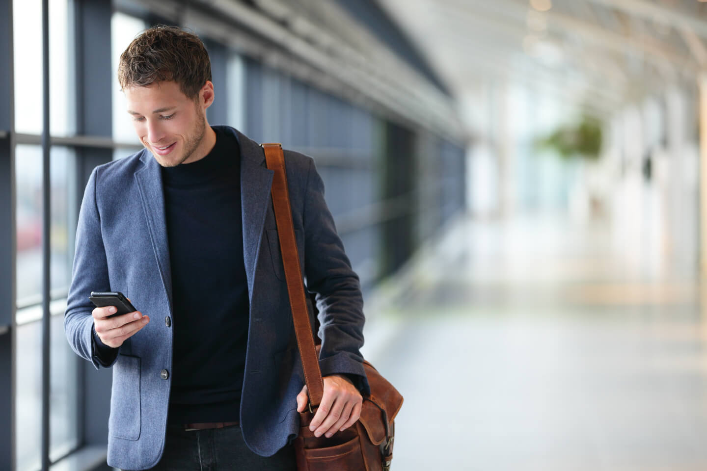 A man smiling after receiving an automated SMS notification